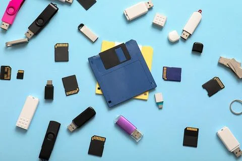 Composition with floppy disks, USB flash drives and SD cards on blue backgrou Stock Photos