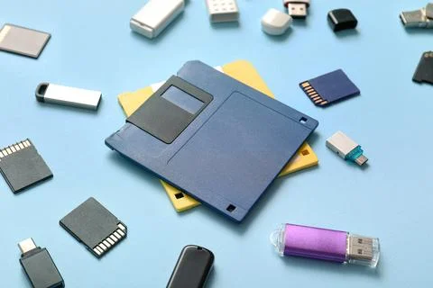 Composition with floppy disks, USB flash drives and SD cards on blue backgrou Stock Photos