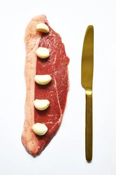 Composition of fresh and raw beef steak and knife on a white background Stock Photos
