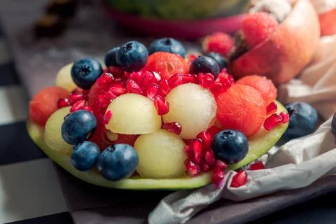 Composition of fresh fruit. Fruit salad with pomegranate, melon, watermelon a Stock Photos