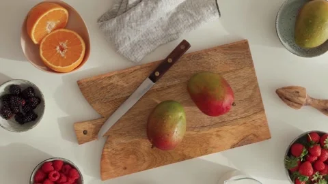 Composition with fresh mango on cutting board, orange and berries. Stock Footage 197156969