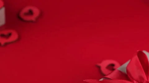 Composition with a gift box tied with a red ribbon with a bow, hearts close-up Stock Footage 167600778
