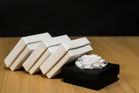Composition of gift boxes. In the center is a dark box with a white bow. White Stock Photos