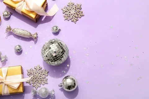 Composition with gift boxes, disco balls and Christmas decor on lilac backgro Stock Photos
