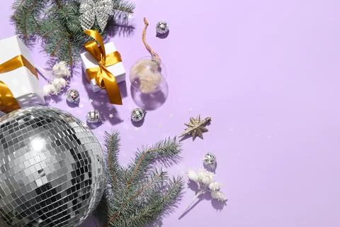 Composition with gift boxes, disco balls and Christmas decor on lilac backgro Stock Photos