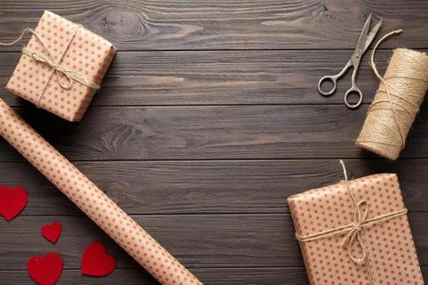 Composition with gifts, scissors, wrapping paper, twine, woolen hearts Stock Photos