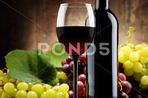 Composition with glass, bottle of red wine and fresh grapes Stock Photos