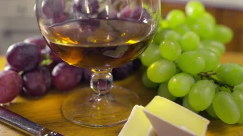 A composition with a glass of brandy grapes brie cheese Stock Footage 49103939