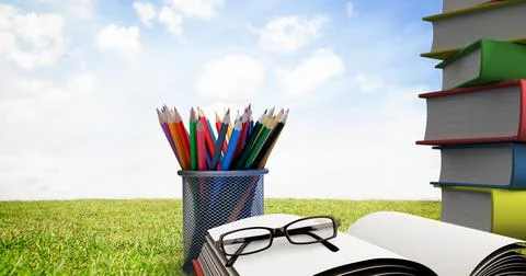 Composition of glasses on opened book, stack of books and container of colour Foto stock