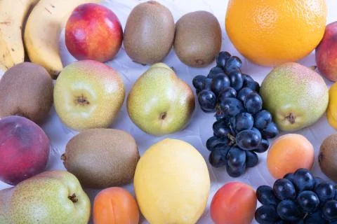 Composition of grapes, pears, peach, lemon, banana on a white plate Stock Photos