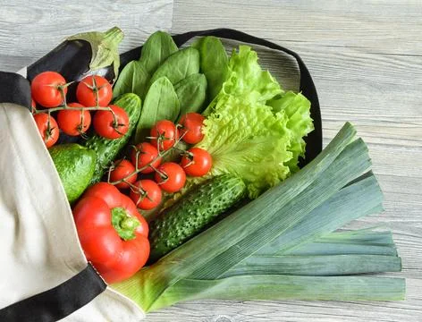 Composition of green and red vegetables with eco bag on wooden table Stock Photos