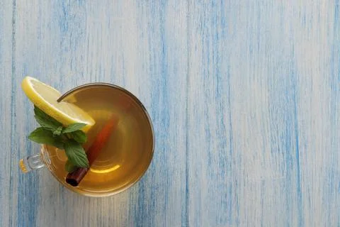 Composition with green hot tea with cinnamon, lemon on a blue wooden backgrou Stock Photos
