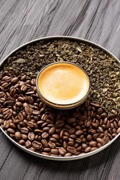 Composition of green tea, coffee beans and coffee in a cup on a dark backgr.. Stock Photos