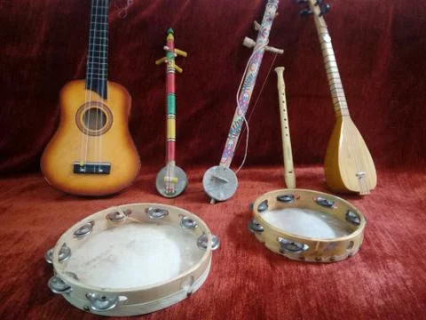 Composition of handmade musical instruments in red background Stock Photos