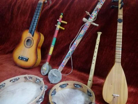 Composition of handmade musical instruments in red background Stock Photos