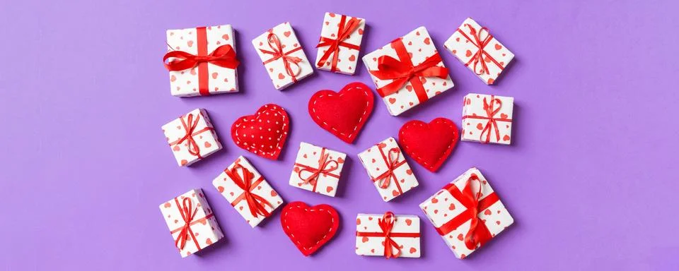 Composition of holiday white gift boxes and red textile hearts on colorful ba Stock Photos