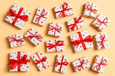 Composition of holiday white gift boxes with red hearts on colorful backgro.. Stock Photos