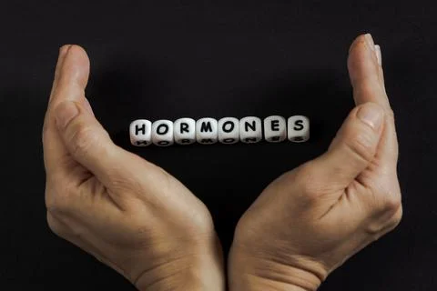 A composition with hormones text and hands Stock Photos