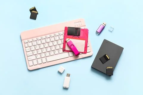 Composition with keyboard and different memory storage devices on blue backgr Stock Photos