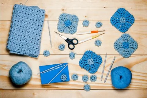Composition of knitting accessories. Blue crocheted square-shaped napkins, ba Stock Photos