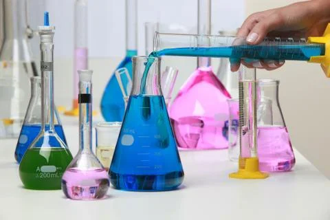 Composition of laboratory material with colored liquids in realistic glass .. Stock Photos