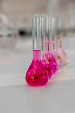 Composition of laboratory material with colored liquids in realistic glass pots Stock Photos