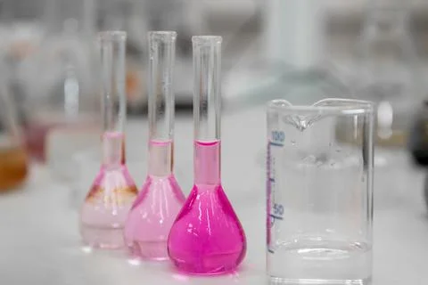 Composition of laboratory material with colored liquids in realistic glass pots Stock Photos