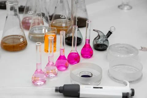 Composition of laboratory material with colored liquids in realistic glass pots Stock Photos