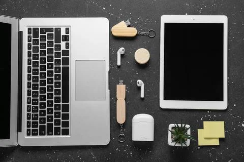 Composition with laptop, tablet computer and modern flash drive on black grun Stock Photos