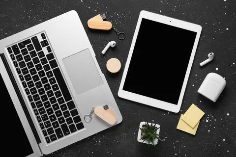 Composition with laptop, tablet computer and modern flash drive on black grun Stock Photos
