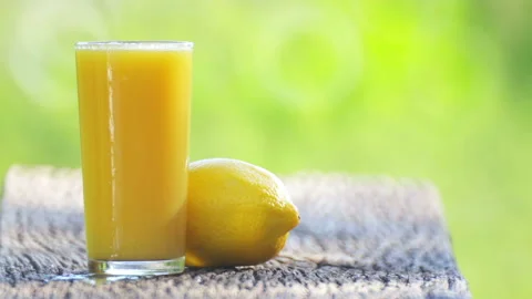 Composition,  lemon and lemon juice in the garden on the table. Stock Footage 114614754