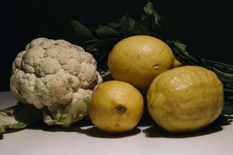 Composition of lemons and cauliflower on white background. Yellow lemons and  Stock Photos