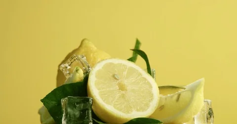 Composition of lemons, leaves and ice cubes. Covered by water drops. Fresh Stock Footage