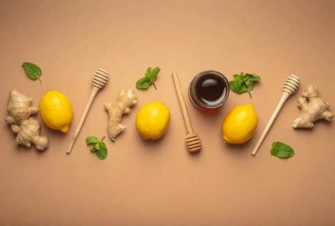 Composition with lemons, mint, ginger, honey in glass jar and honey wooden Stock Photos