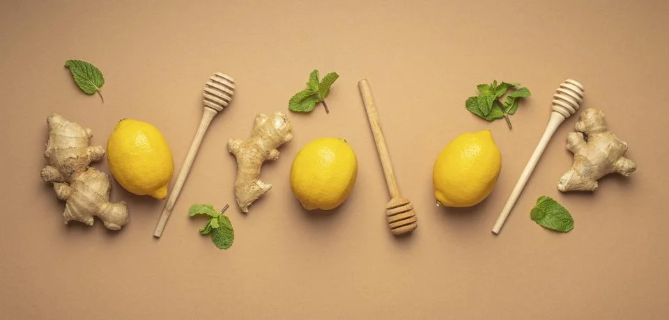 Composition with lemons, mint, ginger top view on simple beige background. Food Stock Photos