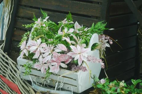Composition of light pink flowers and greenery in a wooden box. Outdoor dec.. Foto stock