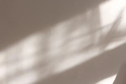 A composition of lights and shadows projected on a beige wall Foto stock