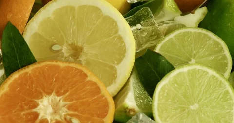 Composition of limen, orange and lime with an ice cubes turning on Stock Footage 76996229