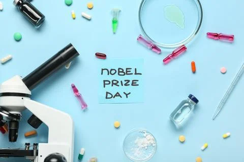 Composition with microscope, medicine and NOBEL PRIZE DAY greeting card on bl Photos