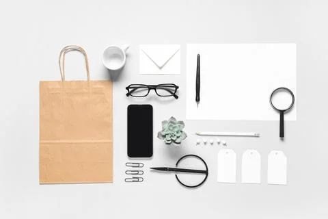 Composition with mobile phone, scissors and delivery paper bag on grey backgr Stock Photos
