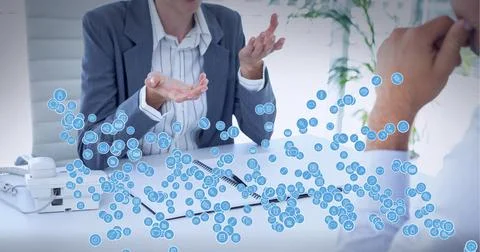 Composition of network of connections with icons over business people talking in 写真素材