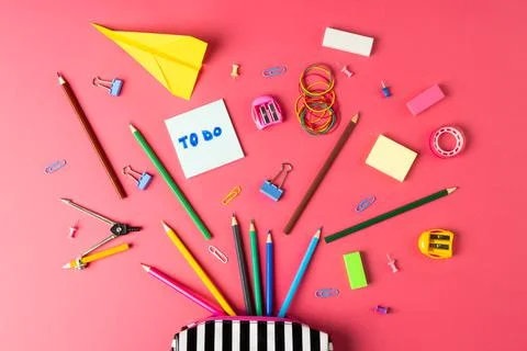 Composition of notebooks, paper plane and school equipment in striped case on Stock Photos