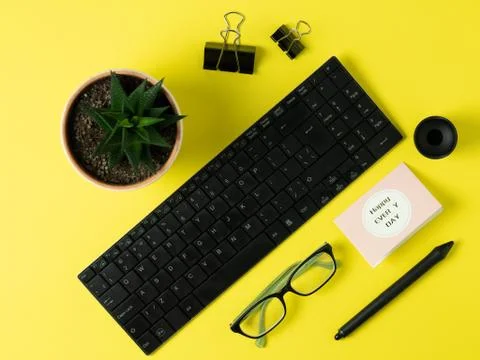 Composition of objects on a bright yellow background. Keyboard, glasses, a pa Stock Photos
