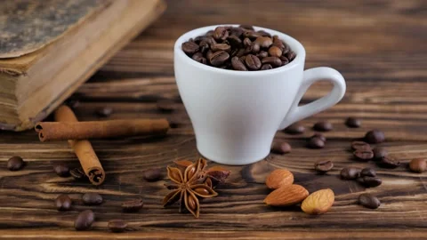 Composition of the old book and cup with beans of coffee on a wooden table. Stock Footage 131004330
