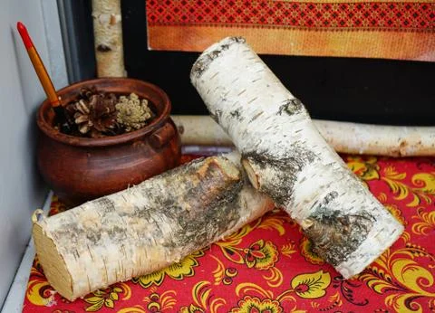 Composition with an old ceramic pot and birch logs. Stock Photos