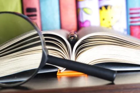 Composition with open book, pen and magnifying glass. Back to school Stock Photos