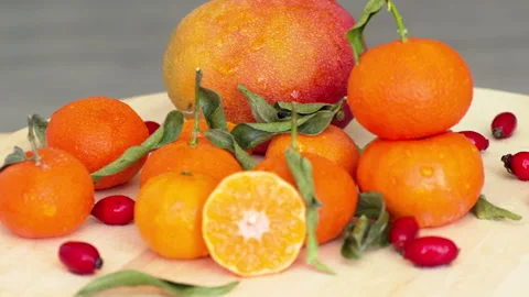 Composition with oranges, mango, rosehip and green leaves Stock Footage 166132229