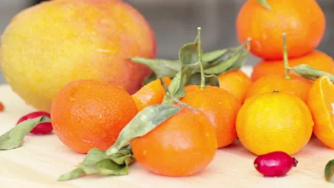 Composition with oranges, mango, rosehip and green leaves, close up Stock Footage 166132249