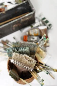 The composition of paint brushes on the background of art studio Stock Photos