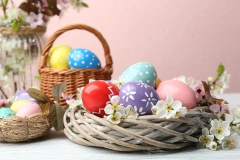 Composition with painted Easter eggs and flowers on table Stock Photos